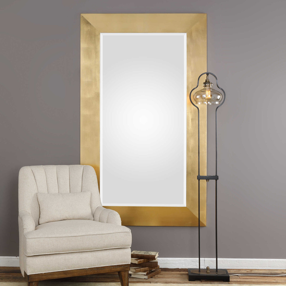 Uttermost 09324 Chaney gold mirror on a gray wall beside a cream channel back chair and floor lamp