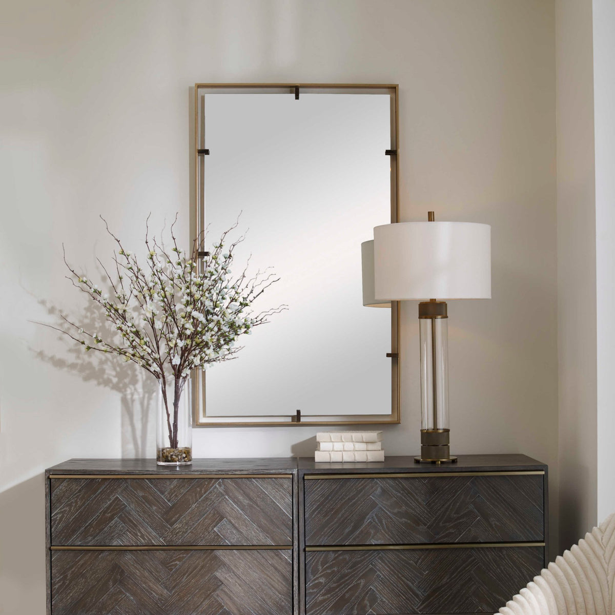 Uttermost 09754 Egon gold mirror above a herringbone front credenza with a table lamp