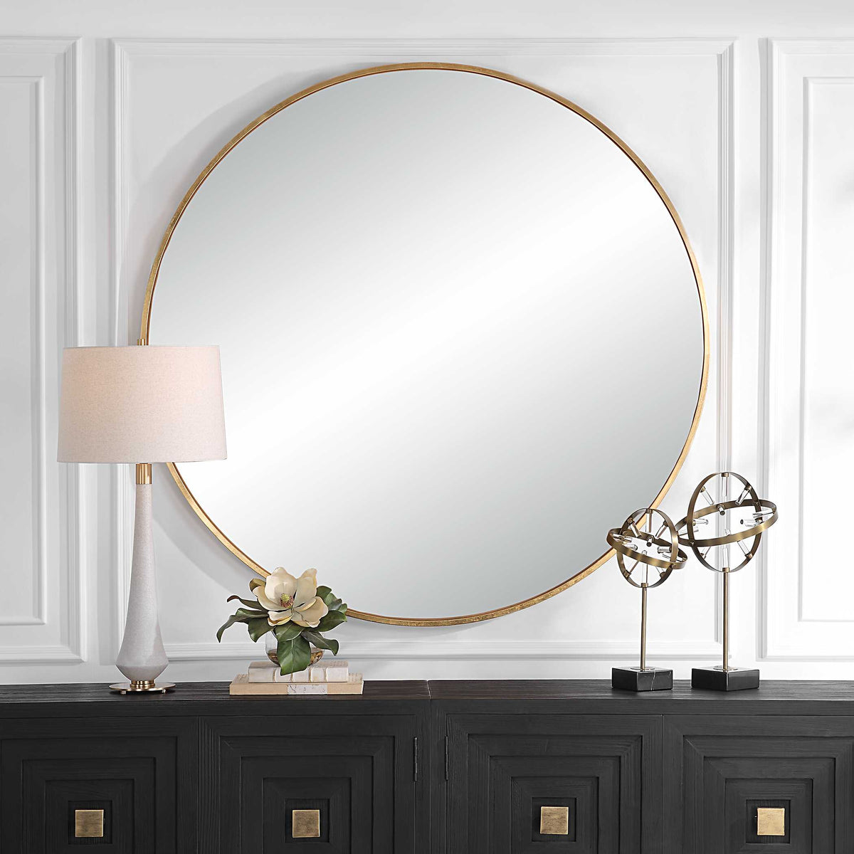 Uttermost 09928 Junius large gold round mirror over a credenza with a lamp and sculptures
