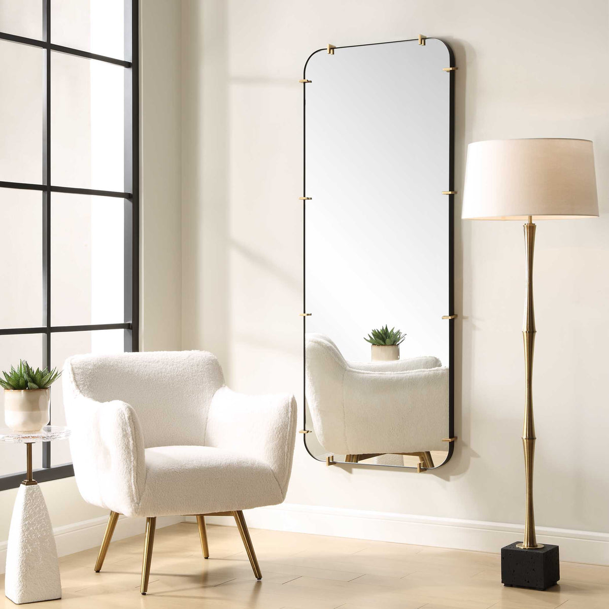 Uttermost 09978 Pali tall mirror beside a white boucle armchair and brass floor lamp