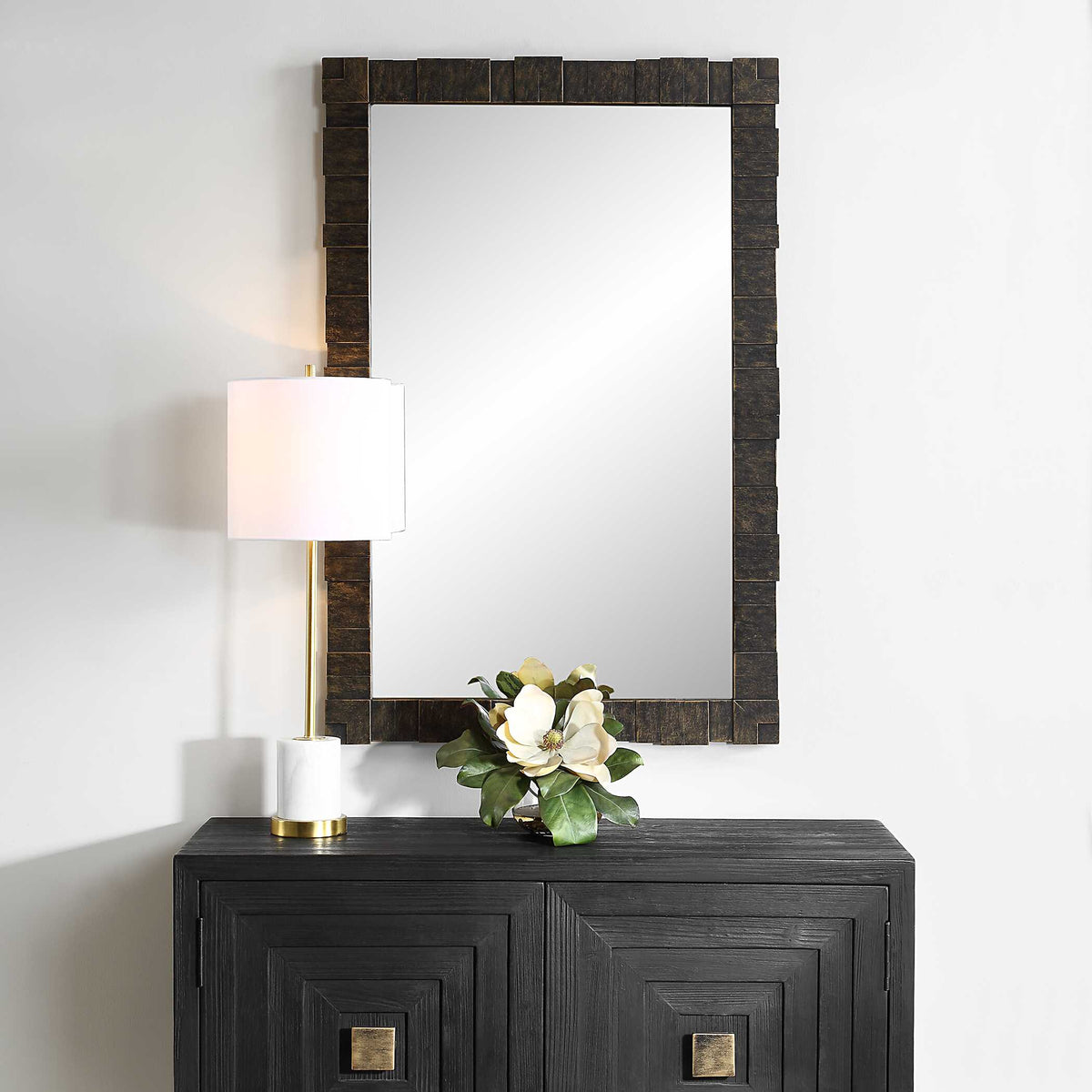 Uttermost 08236 Bustelo collection dark bronze mirror above a credenza with a lamp