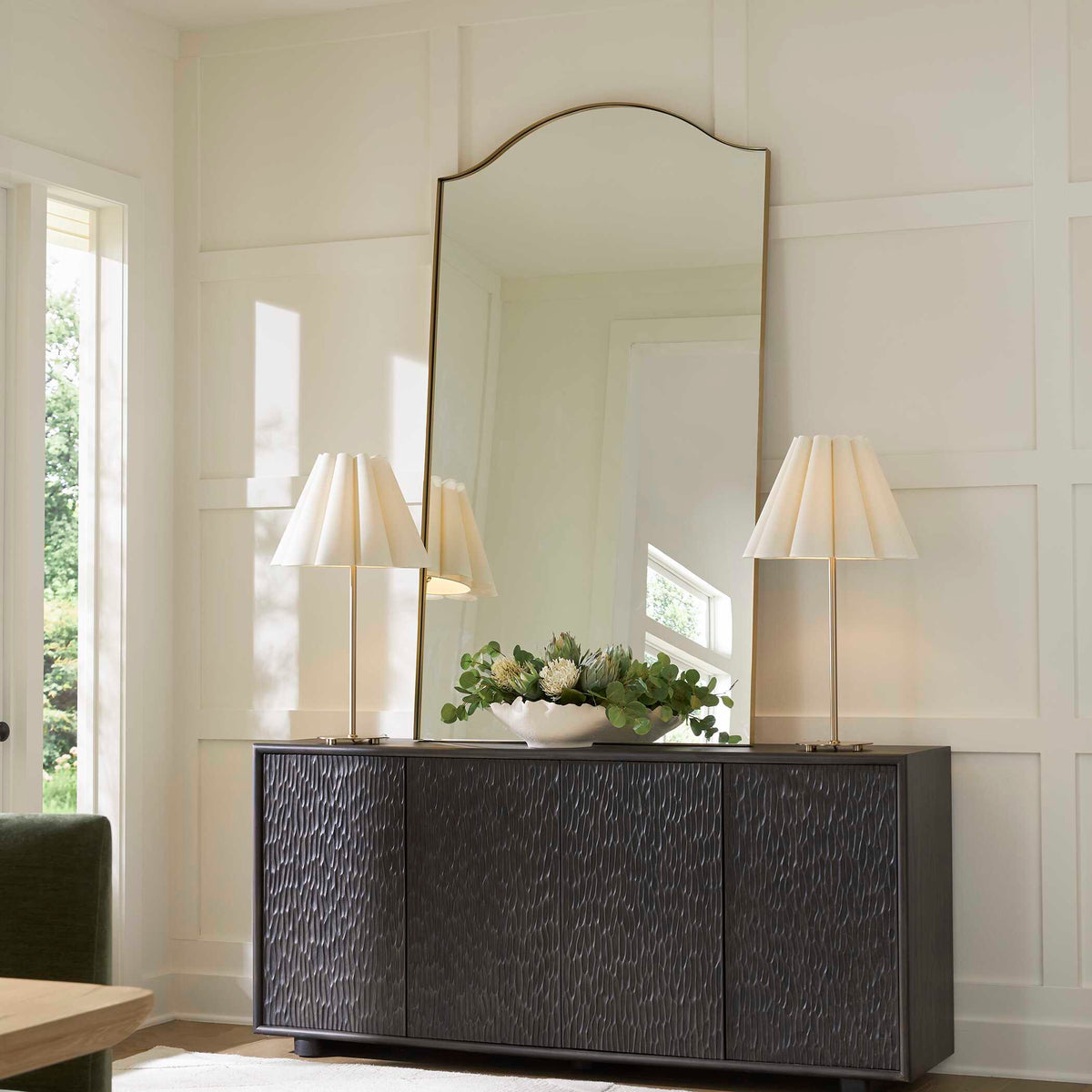 Uttermost 08253 Mallorca collection arch mirror above a textured credenza between two table lamps
