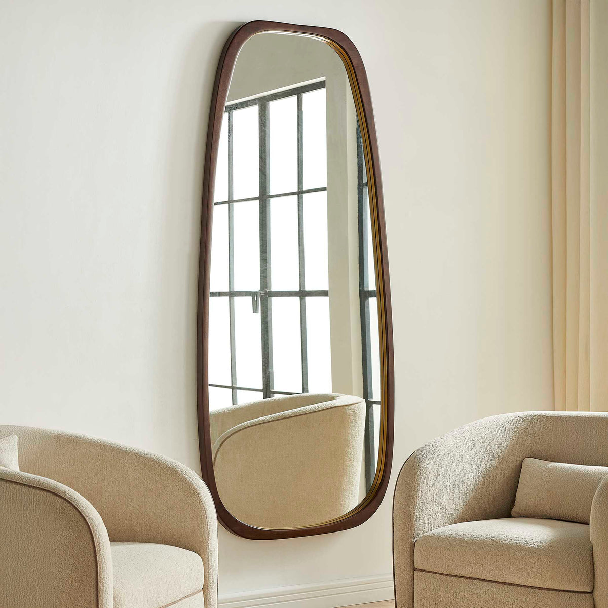 Uttermost 08384 Zachari collection tall mirror between cream chairs, reflecting a paned window