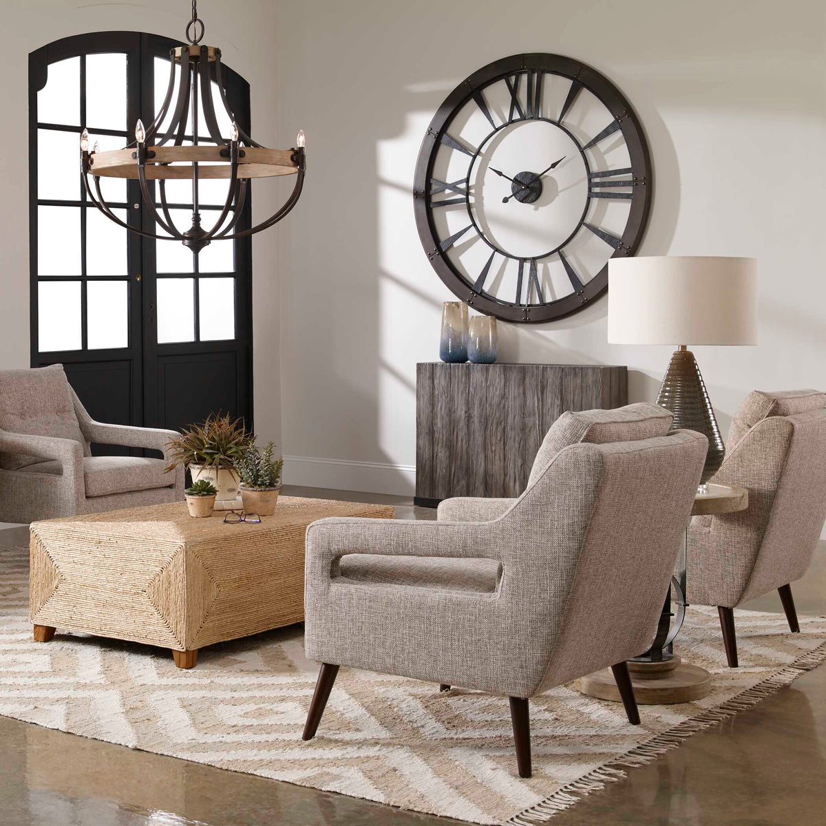 Ronan oversized wall clock in a living room with lounge chairs and a woven coffee table