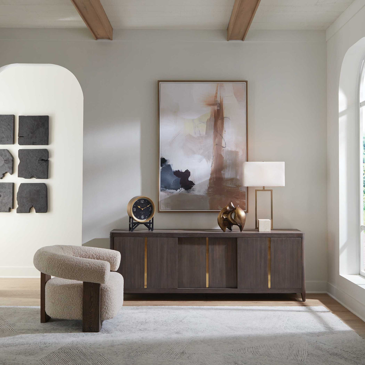 Art Deco table clock on a dark wood credenza in a living room with a boucle chair