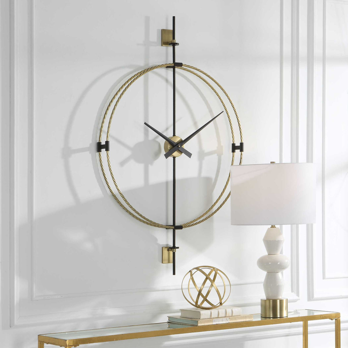 Angled view of a tall modern wall clock with a braided brass ring on a paneled wall