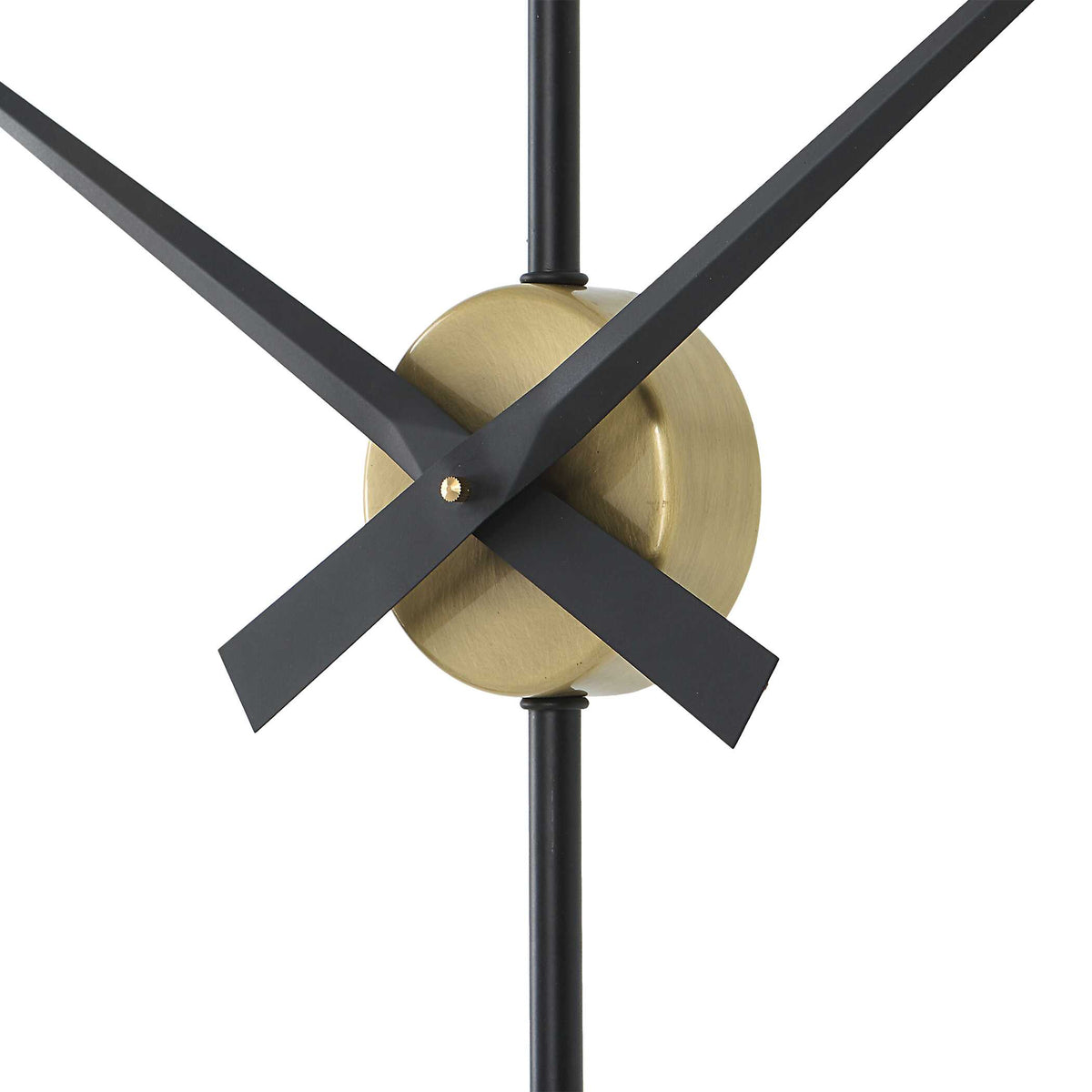 Black clock hands on a brushed brass center hub, minimalist wall clock detail