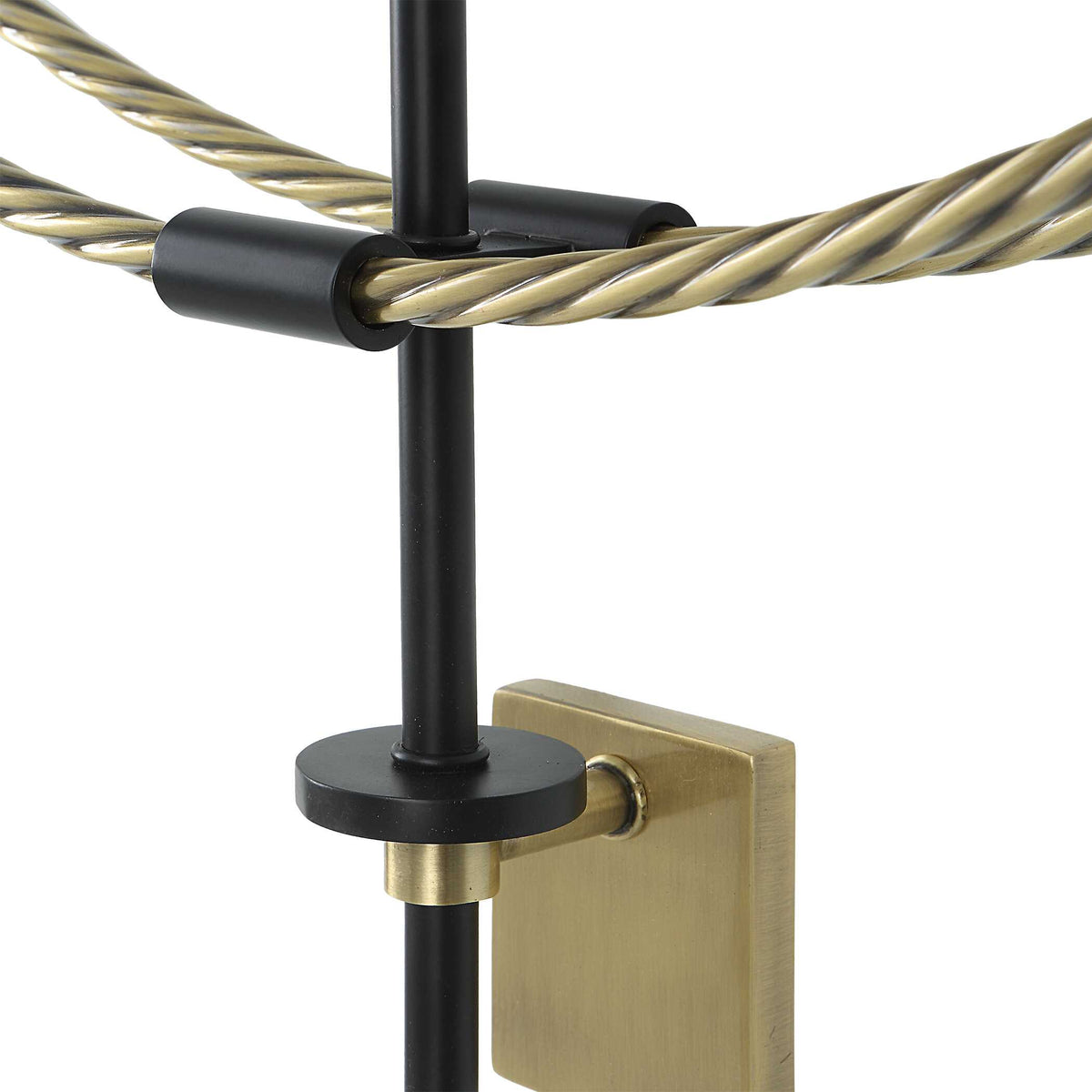 Close-up of the braided brass ring, black clip and brass wall bracket