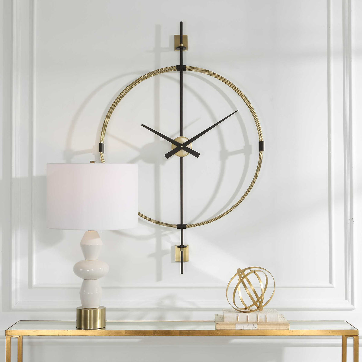 Time Flies brass and black wall clock above a gold console with a table lamp