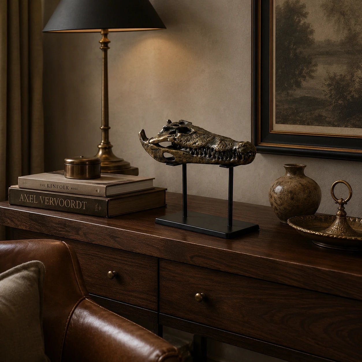 Decorative setup on a wooden console table with books, a lamp, and a skull sculpture.