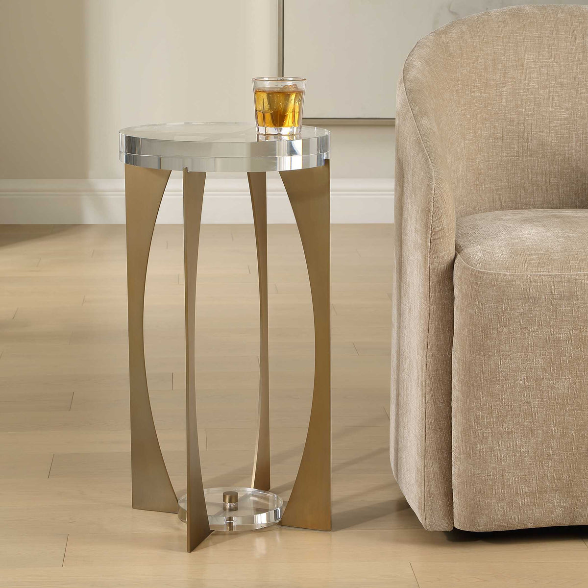 Brass accent table with a thick crystal top beside an upholstered chair, alternate angle, Old Money style