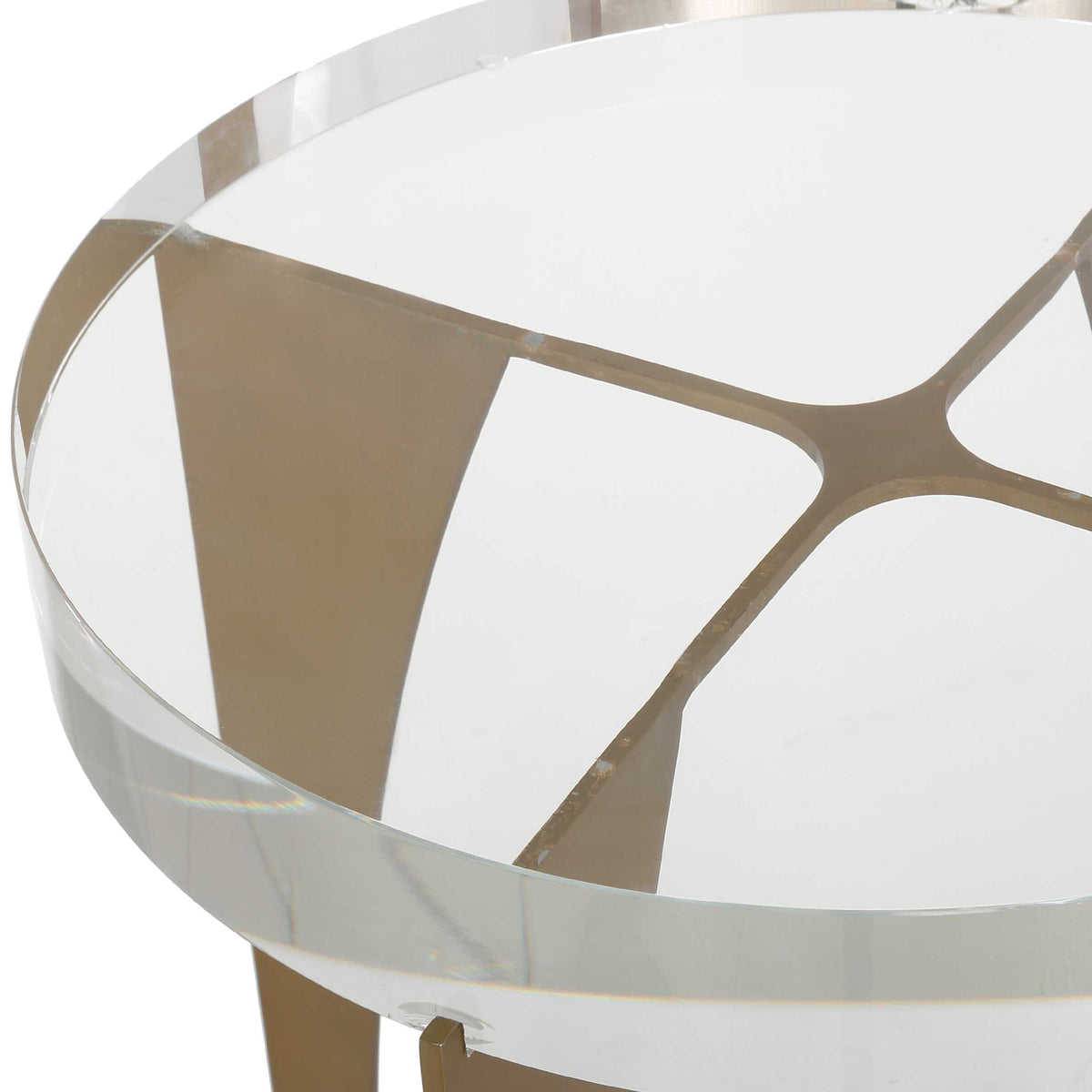 Close-up through the crystal tabletop showing the brass cross frame of a small table, Vintage style