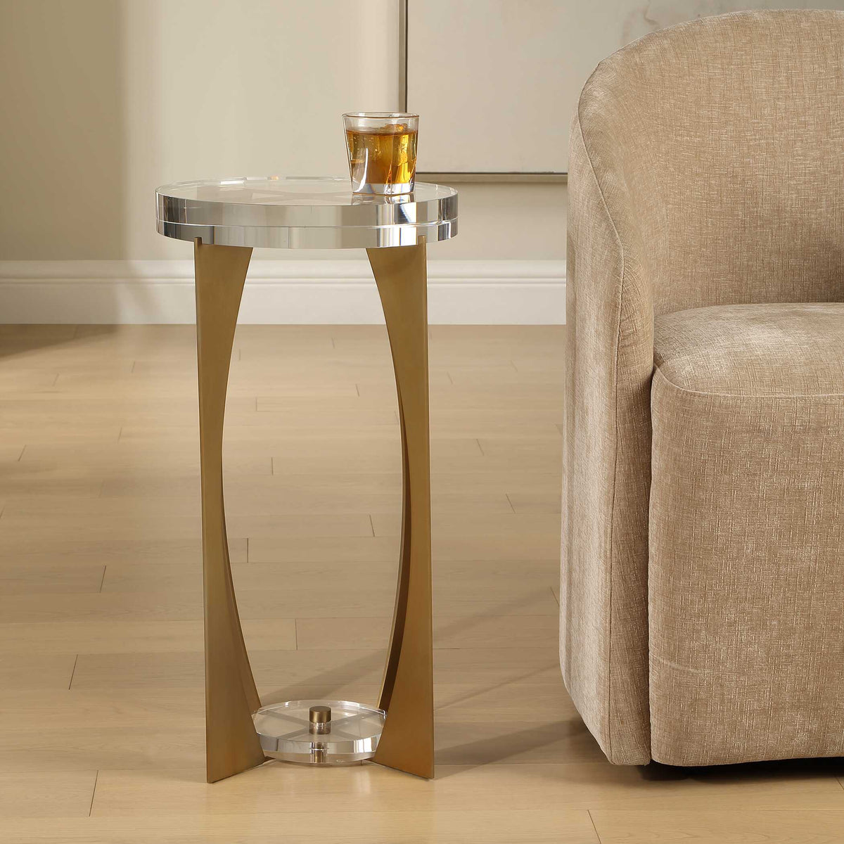 Uttermost 50368 Kolkata drink table holding an amber drink beside a tan upholstered barrel chair