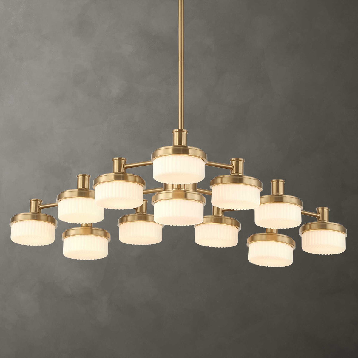 Wedge 12-light brass chandelier against a smoky gray wall