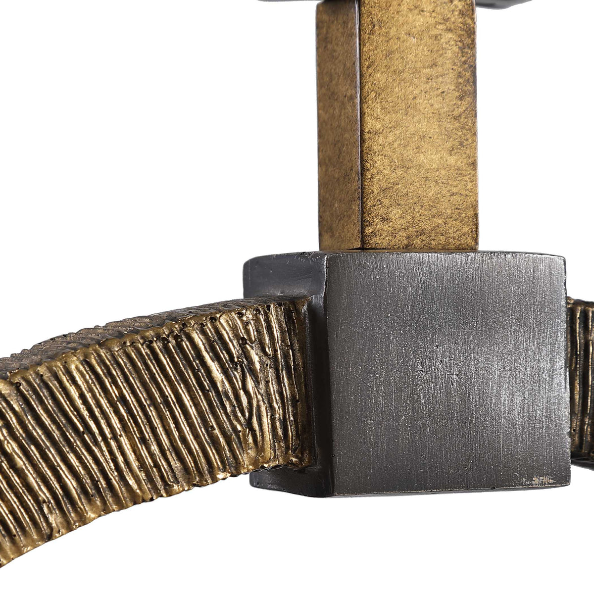 Detail of the hand carved texture on the antique gold ring and the dark bronze accent block above the black marble foot