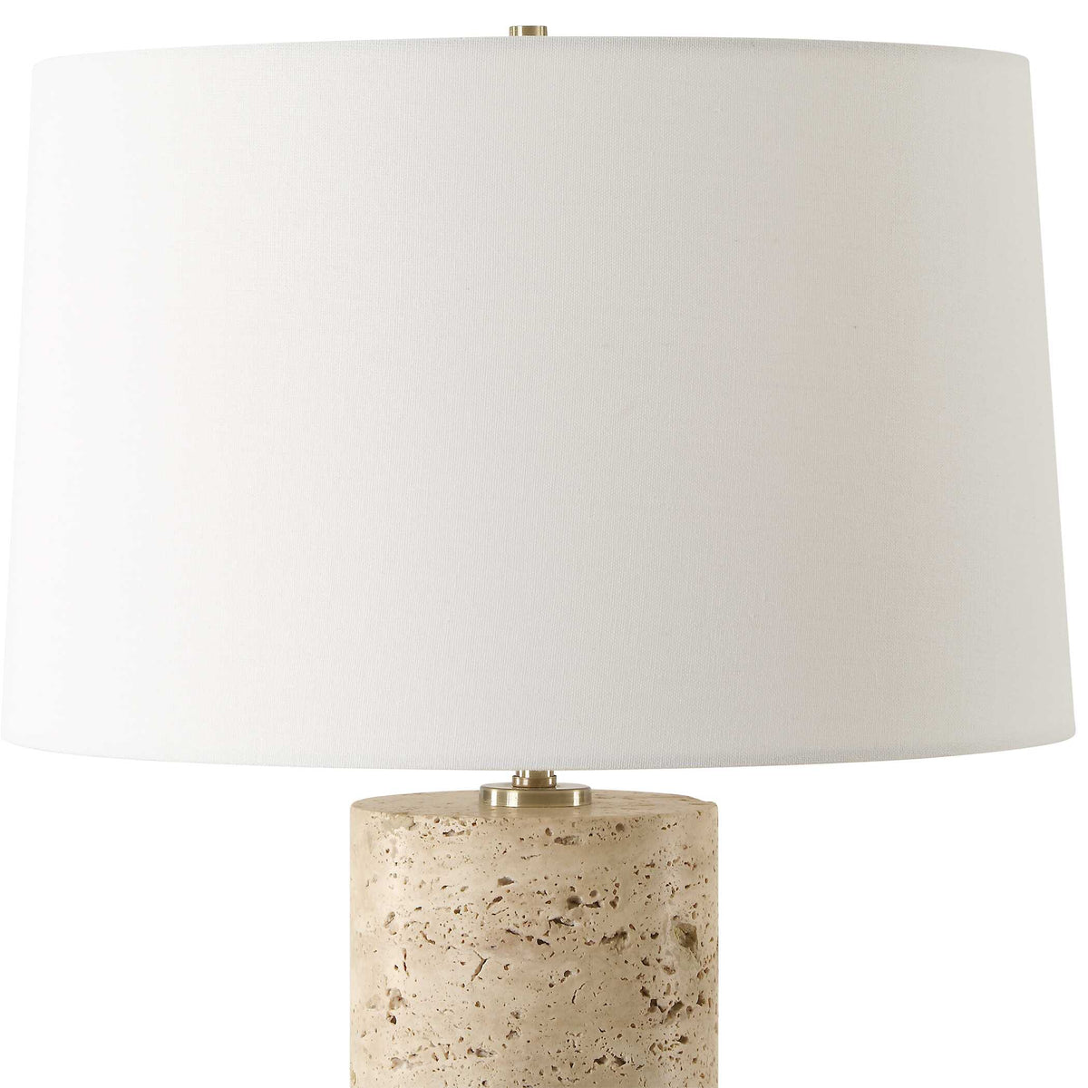 White round hardback shade over the travertine base of a 16 inch wide Organic Modern lamp