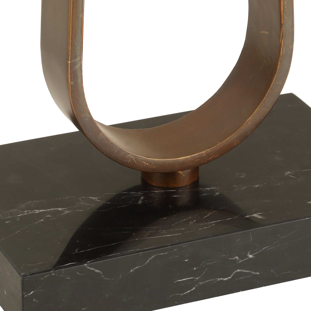 Close up of the black marble foot with white veining and bronze loop on a standing lamp