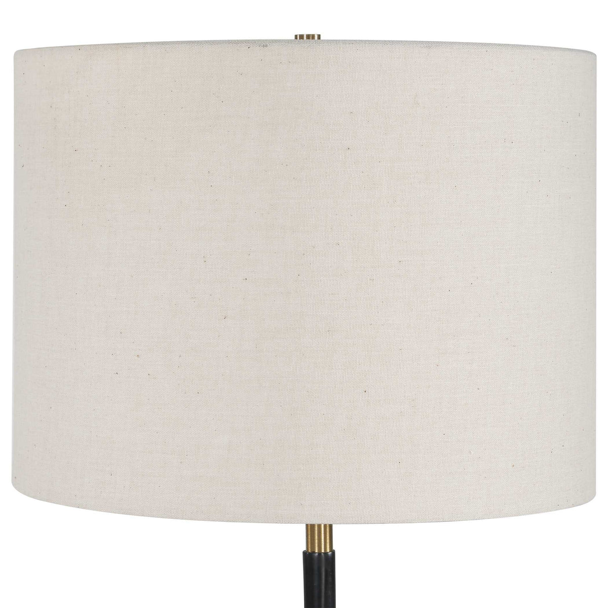 Close view of the white drum hardback shade and antique brass finial on a black iron buffet lamp