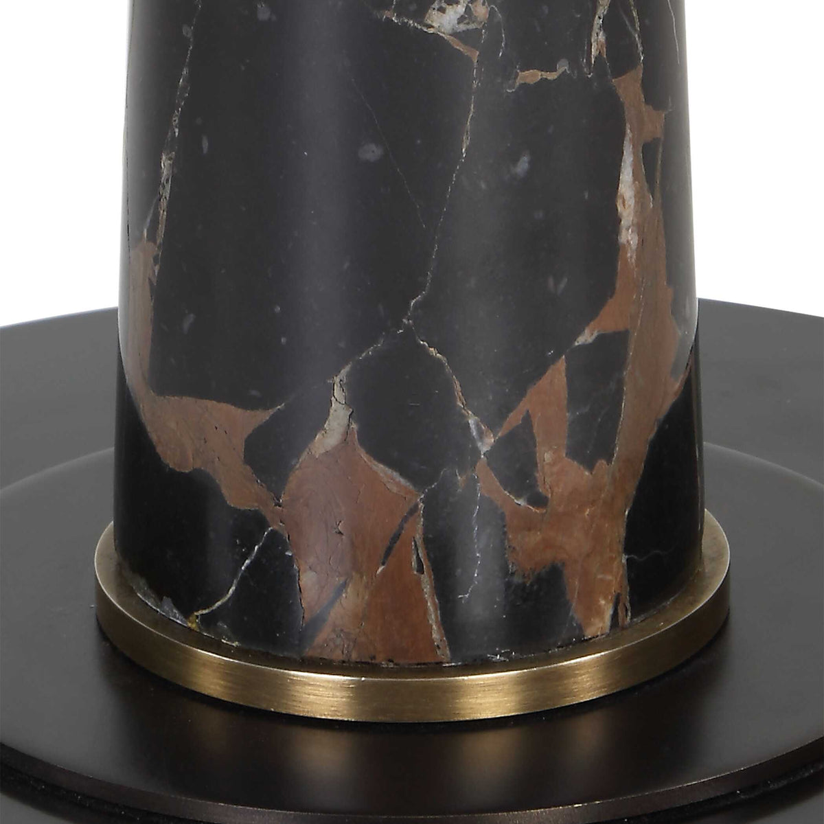 Close up of the black marble section with white and chocolate brown veining above the antique brass band