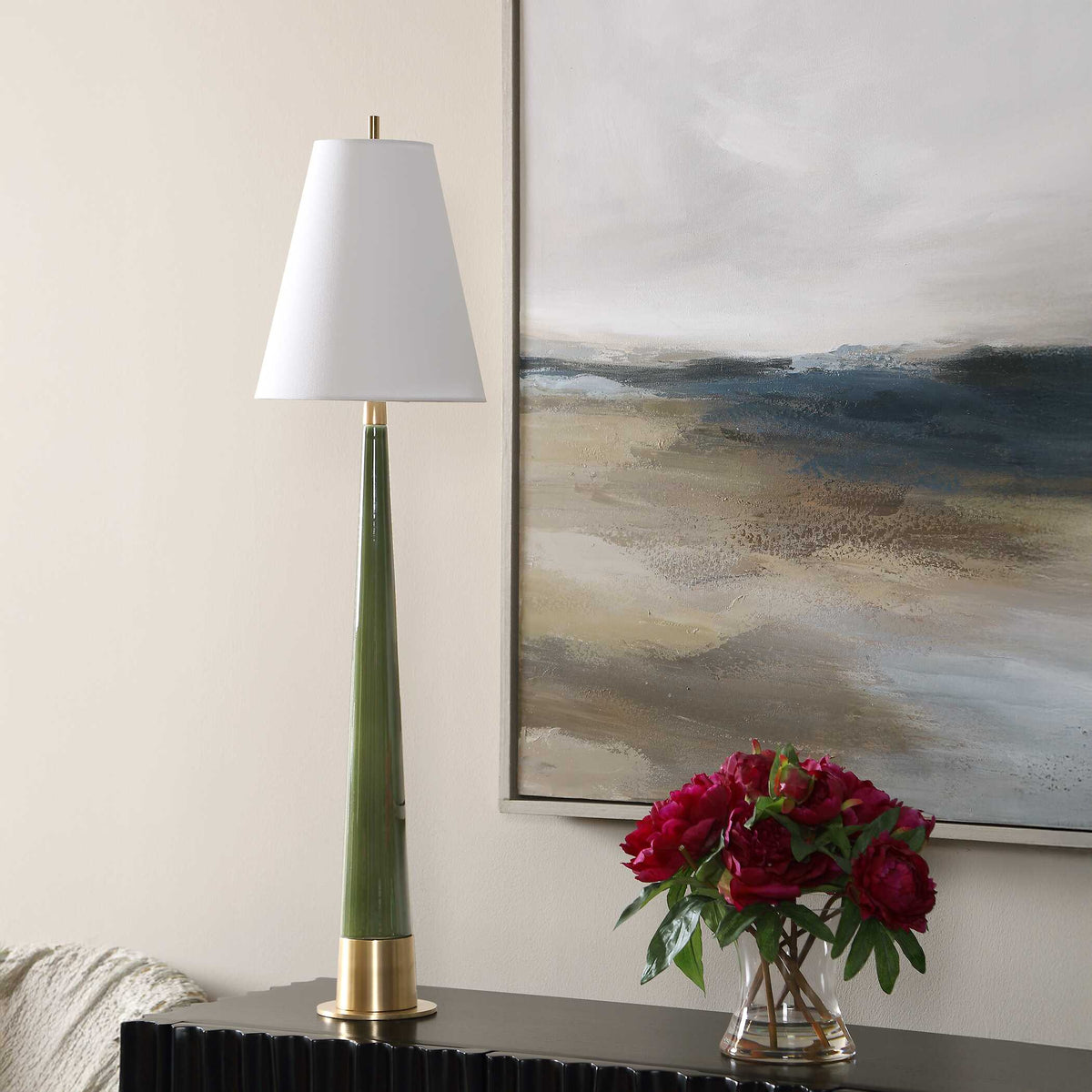 Art Deco living room lamp with a slender tapered moss green body and small white taper shade next to red peonies
