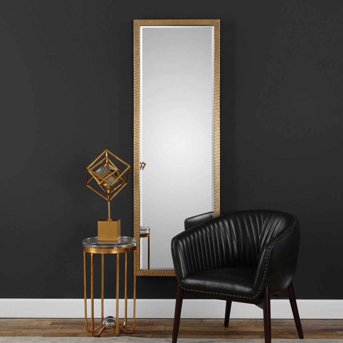 Uttermost 09246 Vilmos gold mirror on a charcoal wall beside a leather channel tufted chair and gold side table