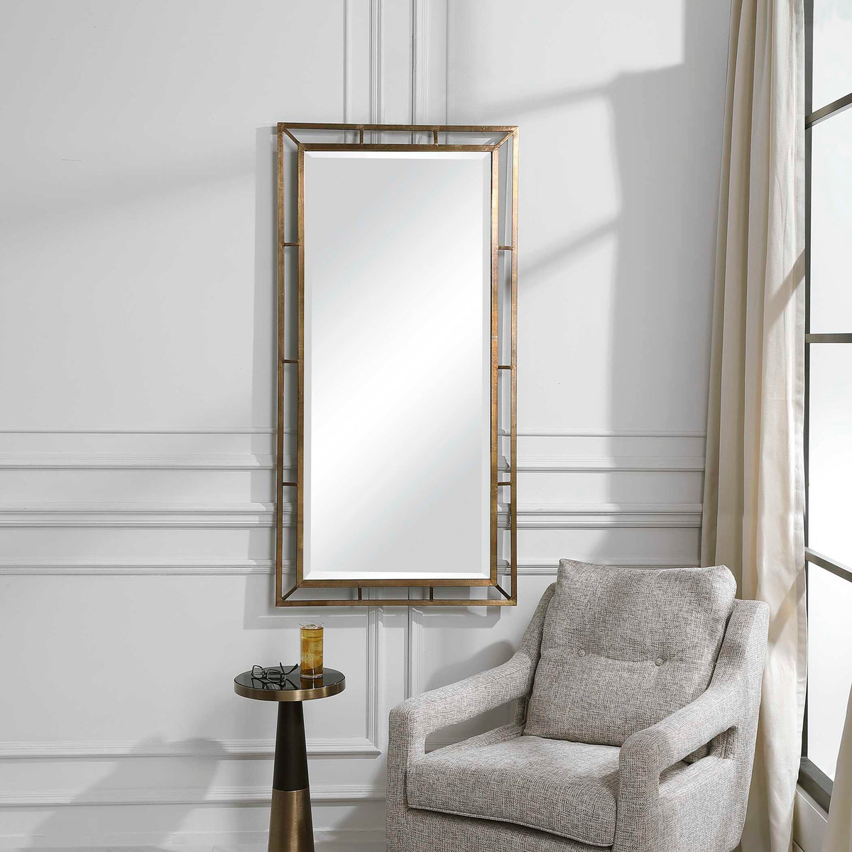 Uttermost 09675 Farrow copper mirror above a pedestal side table beside a gray armchair