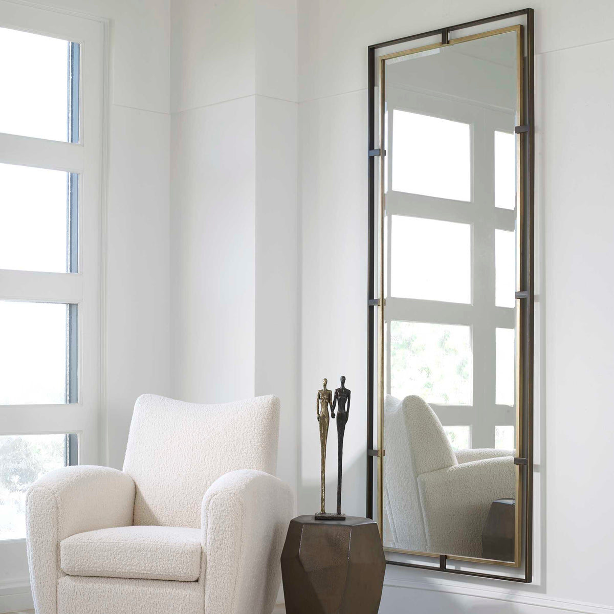 Uttermost 09776 Carrizo tall mirror in a bright living room beside a boucle armchair