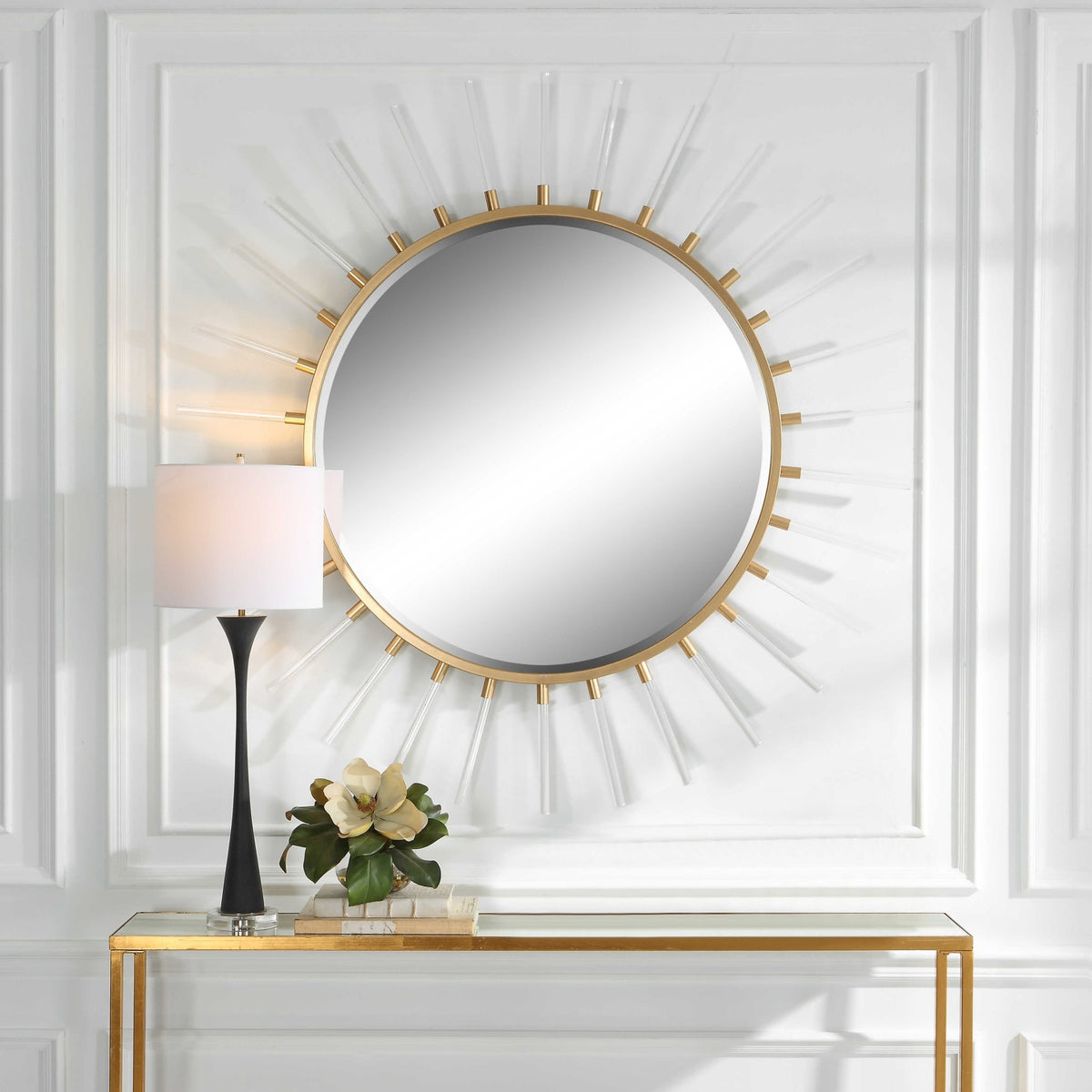 Uttermost 09883 Oracle starburst mirror above a gold console with a table lamp