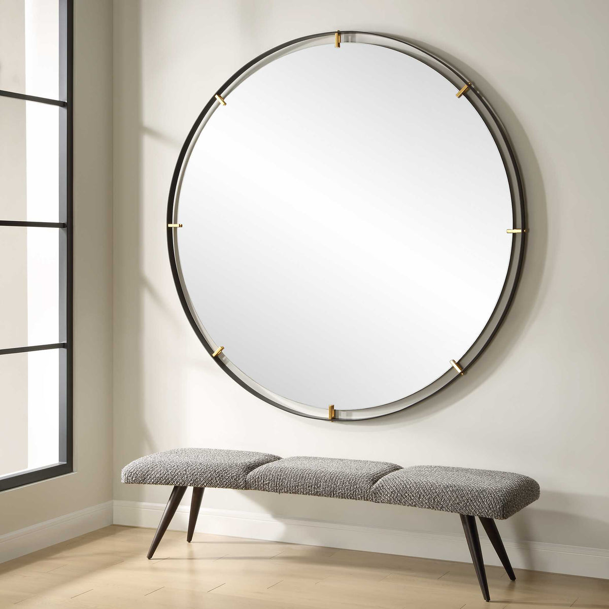 Uttermost 09982 Grand Pendulum round mirror above an upholstered bench in an entry