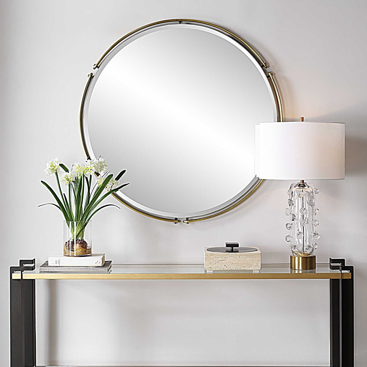 Uttermost 08216 Wesley collection round mirror above a glass console table