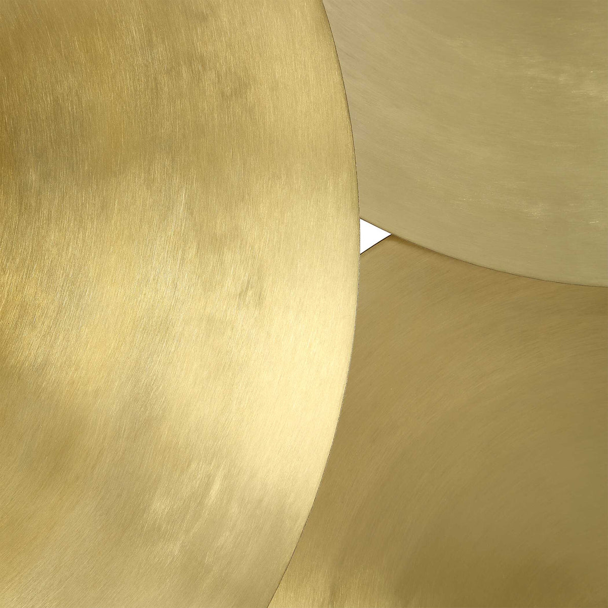 Art Deco close-up where two brass plated discs overlap, showing fine lines in the gold surface