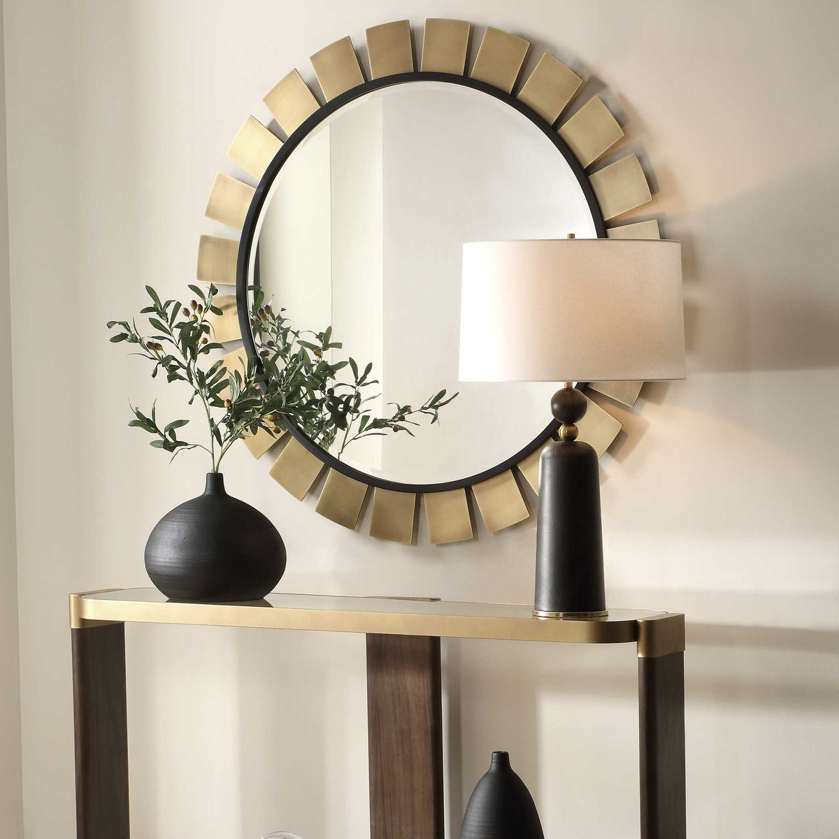 Brass sunburst entryway mirror over an entry table, angled view