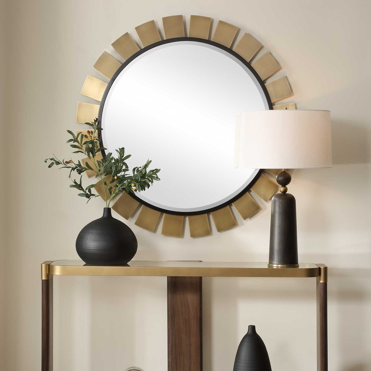 Uttermost 08263 Toluca collection round mirror above a console table with a lamp and vase