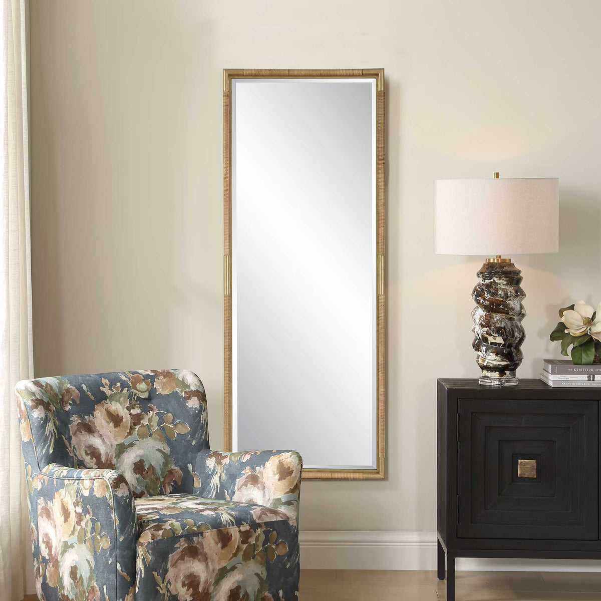Uttermost 08296 Kampar collection tall mirror beside a floral armchair and a nightstand
