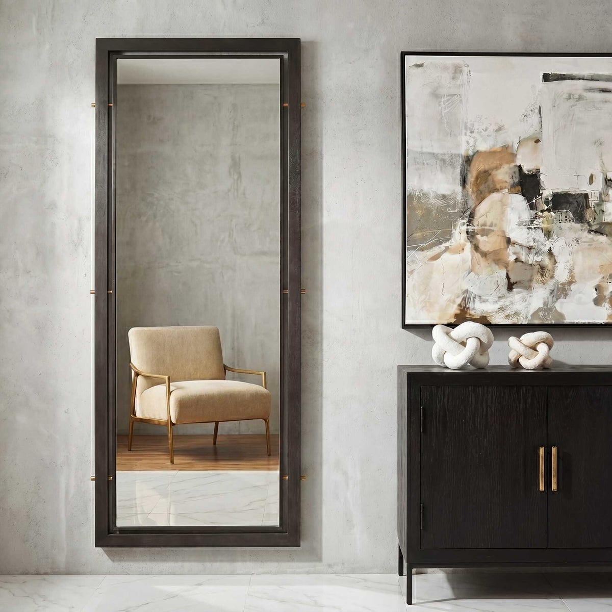 Uttermost 08326 Westley collection tall mirror on a plaster wall beside a dark cabinet and abstract art