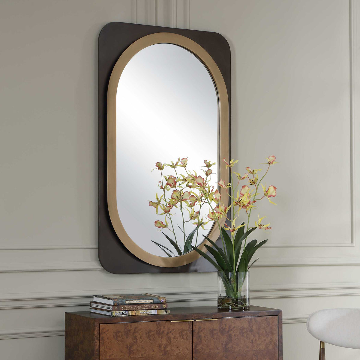 Capsule shape accent mirror with a gold inner frame, angled view