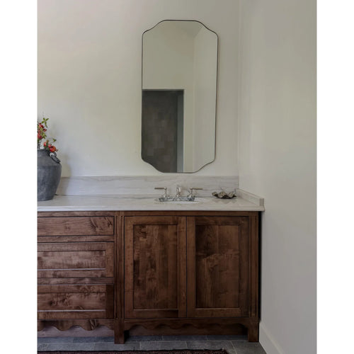Bathroom mirror styled above a marble-top vanity
