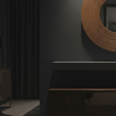 A short video of a dark interior setting with a circular wall art piece and a console table.