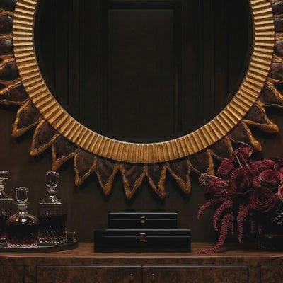 Short product video of Ambella Home Estrella Mirror, 40W x 3D x 40H round sunburst wall mirror with bronze and gold frame above a dark credenza in a luxury hallway