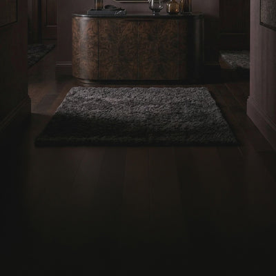 Short product video of the 38 Wavy Mirror - Antiqued Brass by Ambella Home, an elongated tapered wall mirror with a softly scalloped top and antiqued brass frame styled above a dark credenza in a luxury entryway