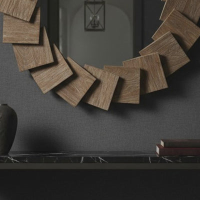 A short video of a round wooden mirror on a dark wall with a black console table below.