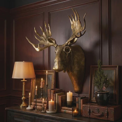 product video of a Eugene the Moose oversized showstopper brass antique gold wall mount displayed as gold-wall-decor above a styled console with candles, framed art, and vintage accents
