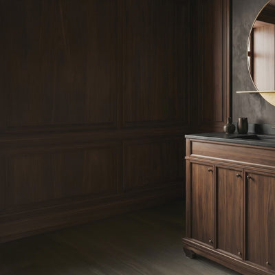 A short video of a bathroom vanity with round mirror and dark wall