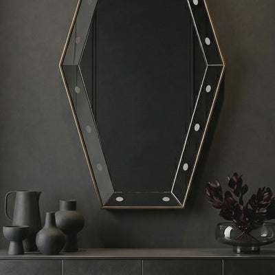 Short product video of Ambella Home Key Hole Mirror in antique gold, 30W x 5D x 54H faceted geometric wall mirror above a dark credenza in a luxury hallway